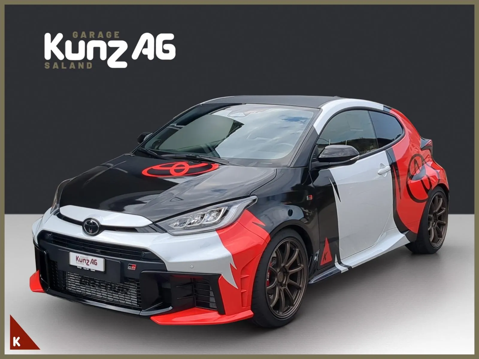 Schräge Frontansicht eines weiss-schwarz-rot folierten Toyota GR Yaris 1.6 Turbo Sport 4x4.