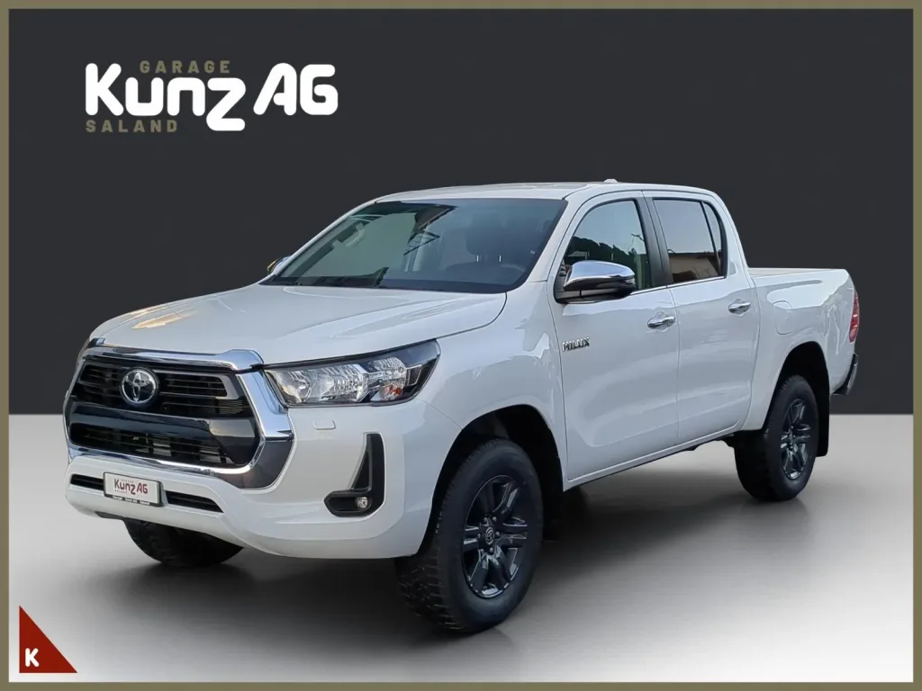 Schrägansicht von vorne links eines weissen Toyota Hilux Double Cab Pick-up vor grauem Hintergrund.