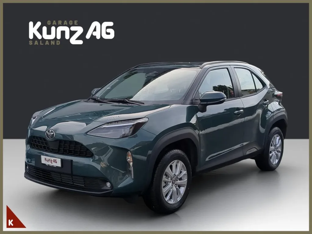 Schrägansicht von vorne links auf einen dunkelgrünen Toyota Yaris Cross Comfort AWD-i im Studio.
