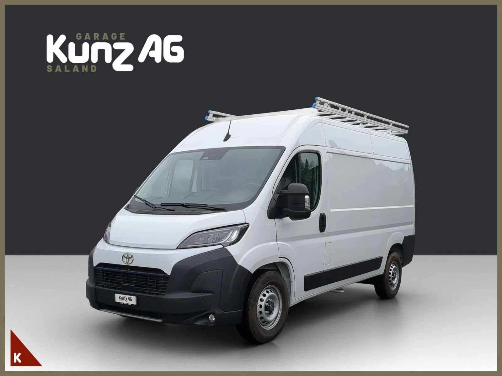 Schräge Frontansicht eines weissen Toyota Proace Max L2H2 Lieferwagens mit Dachträger vor grauem Hintergrund.
